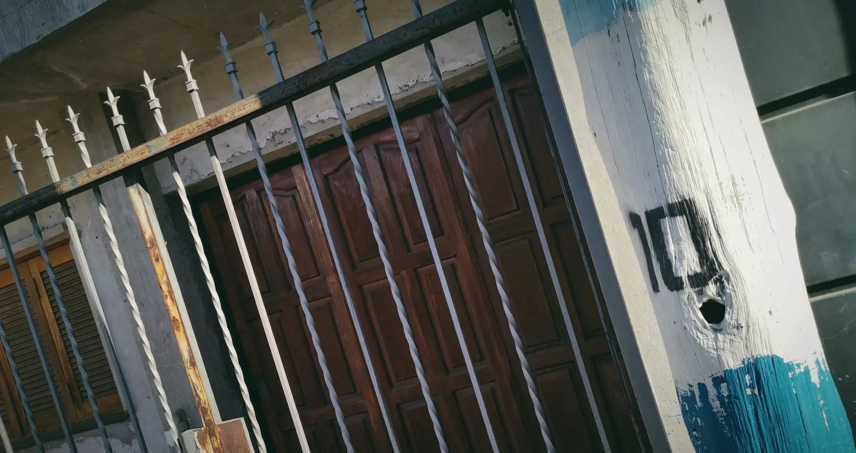 An iron gate and painted post with a hand-painted 10, in Rosario.