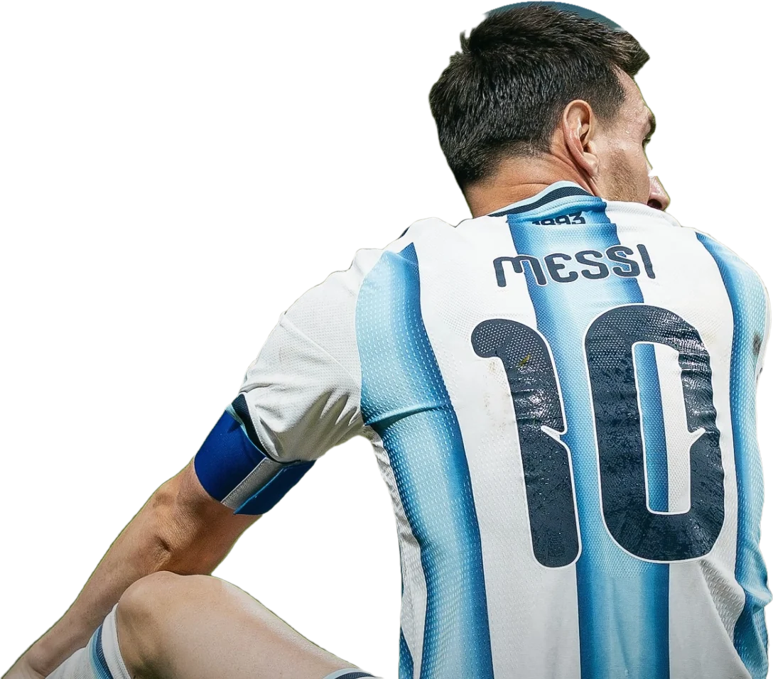 Lionel Messi seated on the grass, seen from behind and turning his head, in Argentina's number 10 shirt.